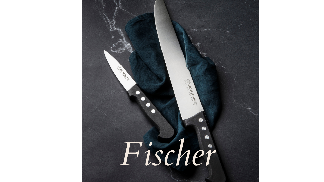 Photo d'un couteau saignant Fischer Bargoin de la gamme classique et d'un couteau de boucher de la gamme Fischer Bargoin classique. Ils sont mis en valeur sur une table noire marbrée.